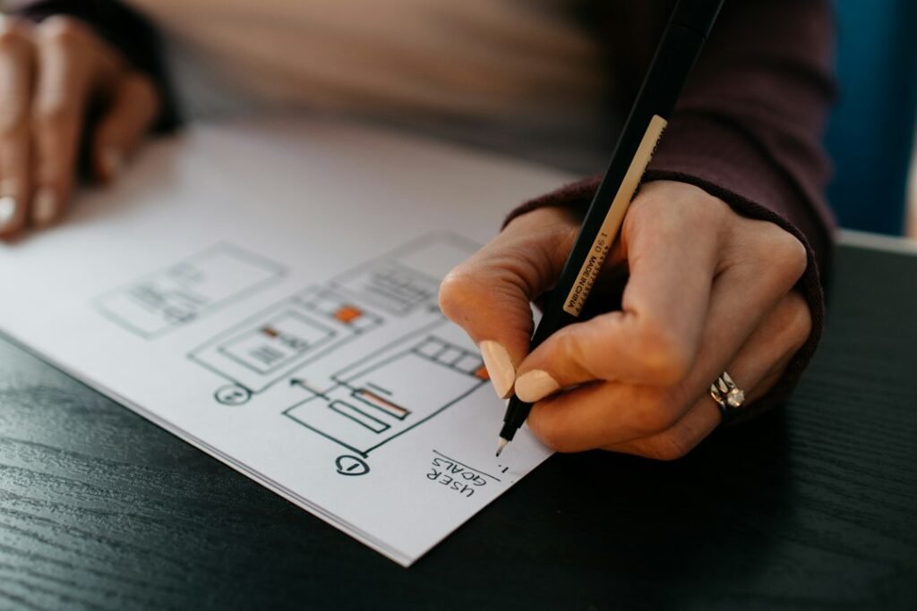 Hands sketching a website wireframe during the planning stage