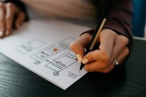 Hands sketching a website wireframe during the planning stage