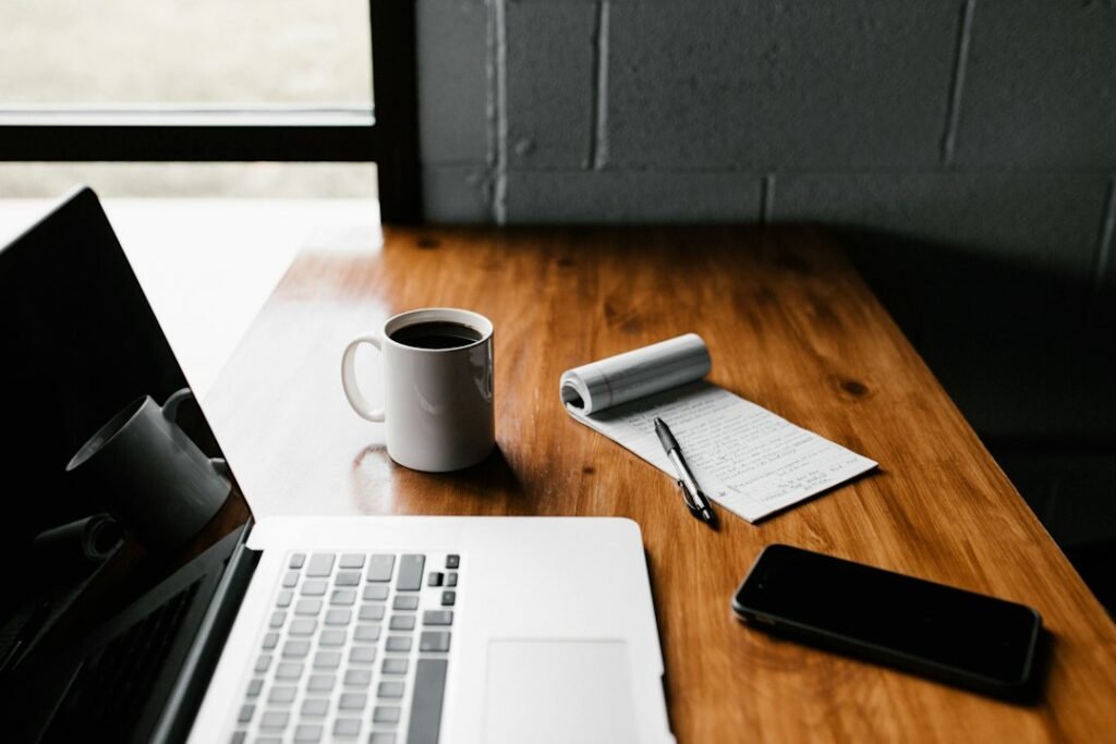 Notebook and laptop on a desk while preparing a website project brief