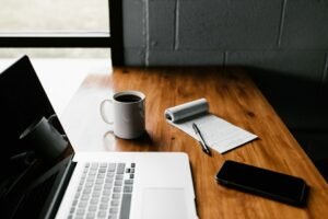 Notebook and laptop on a desk while preparing a website project brief